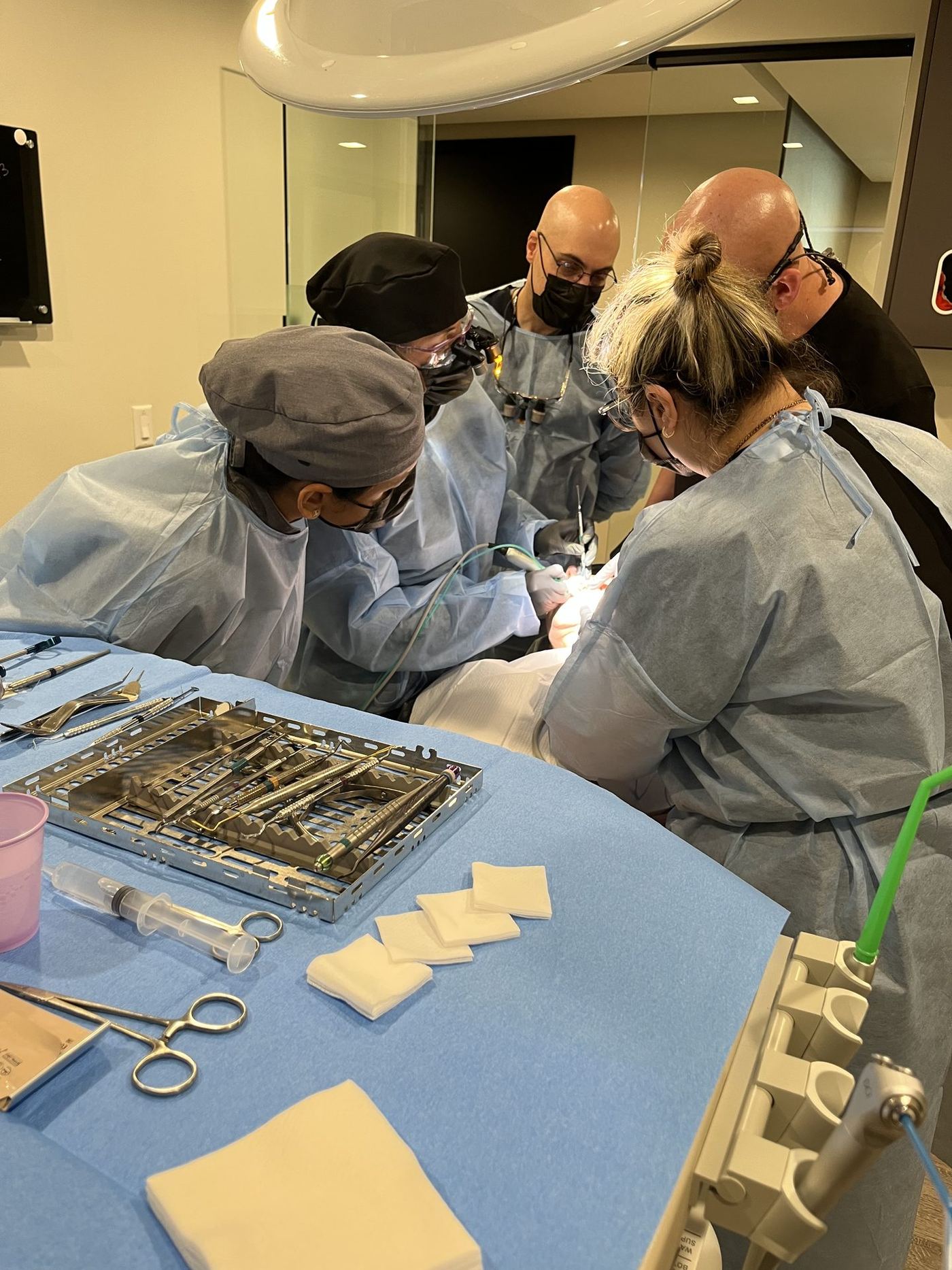 Dentist placing an implant on a live patient under instructor supervision during the 3-day live surgical course